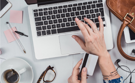 person using laptop with debit card