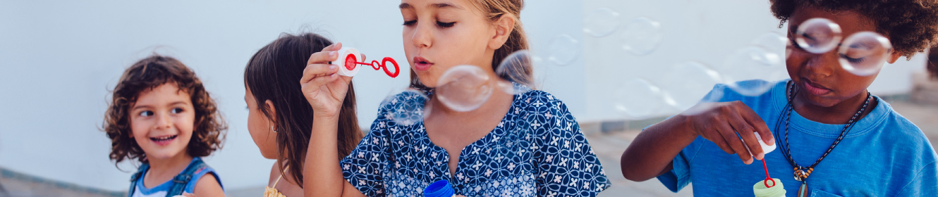 children outside blowing bubbles