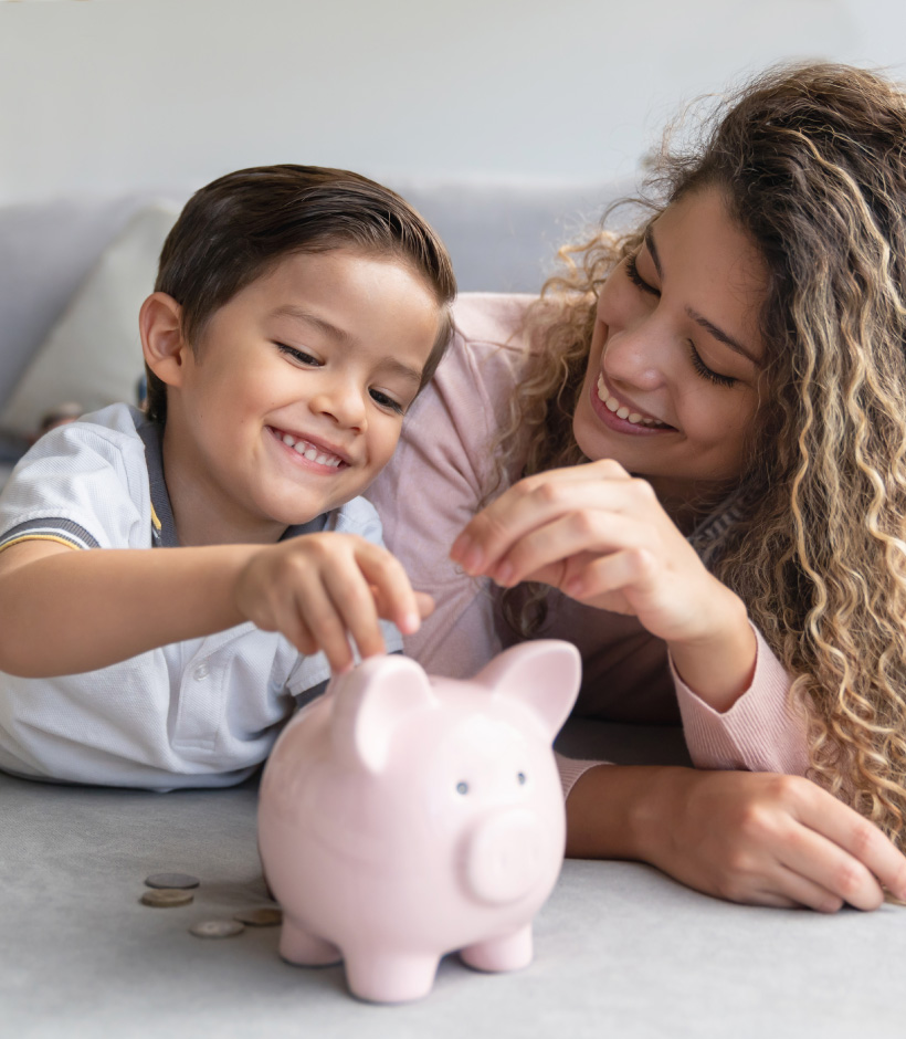mom and child putting money in piggy bank