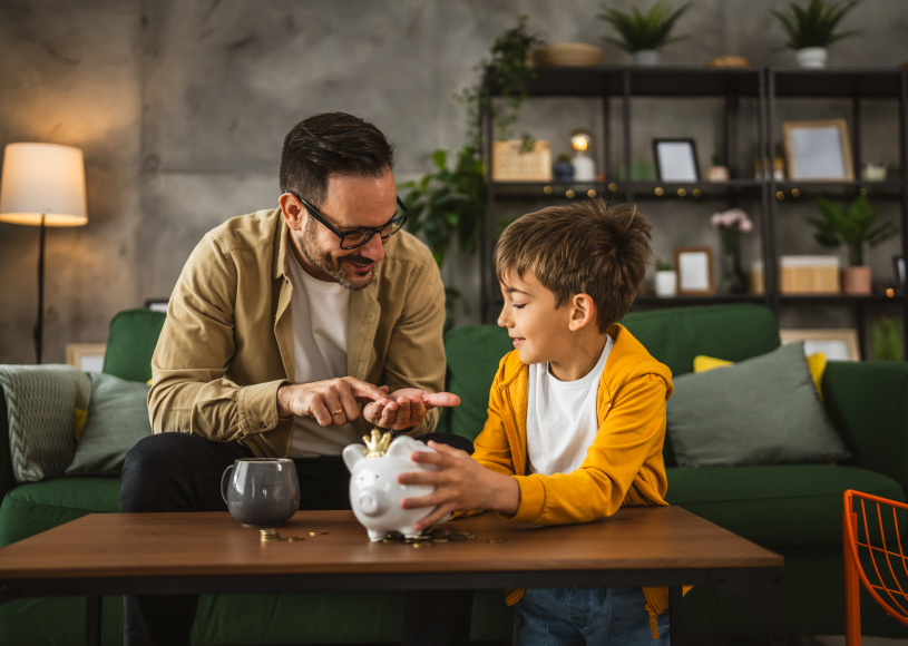 dad and son counting money with piggy bank