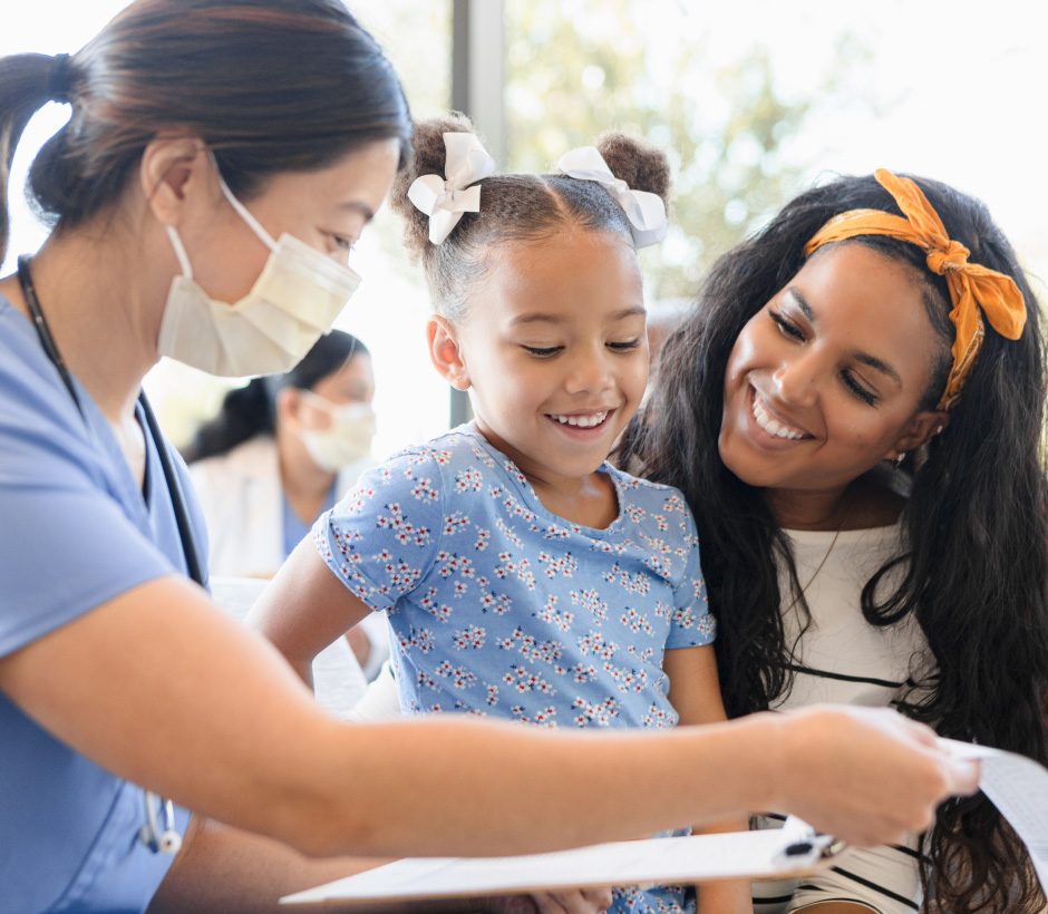 mother and daughter looking at clipboard with a nurse