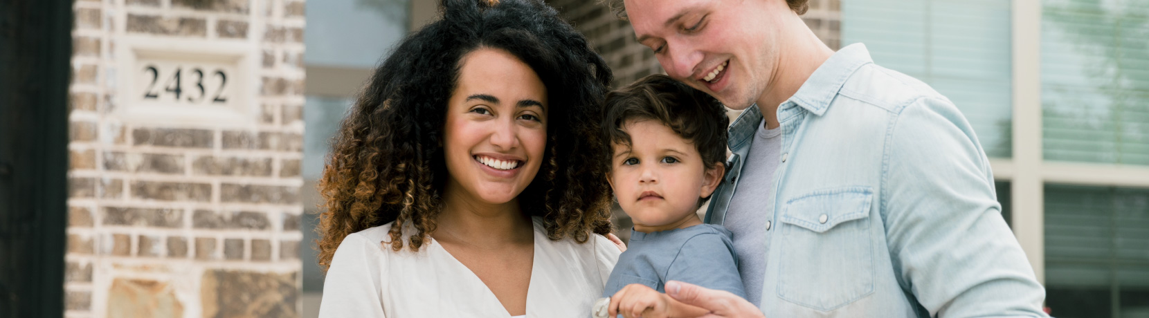 couple with child in front of home