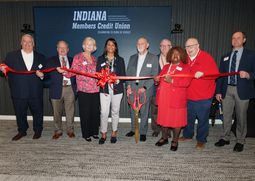 people holding ribbon for grand opening