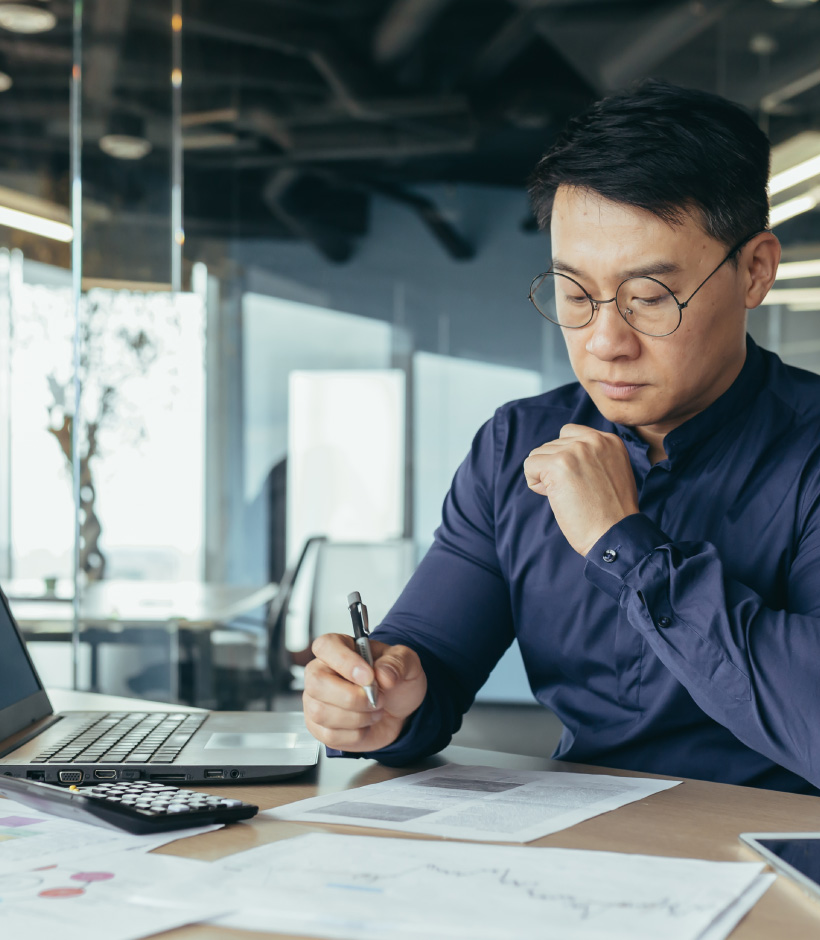 person writing on paper at desk