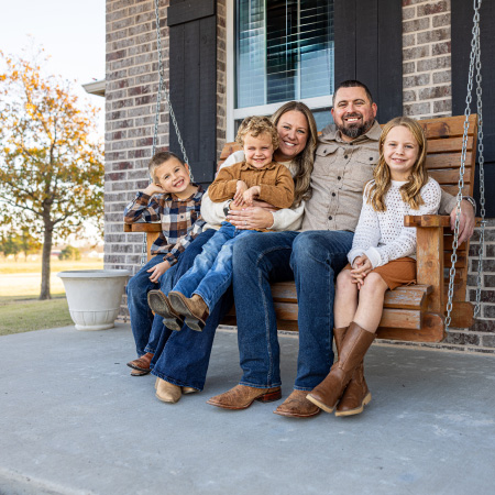 family on swing on porch