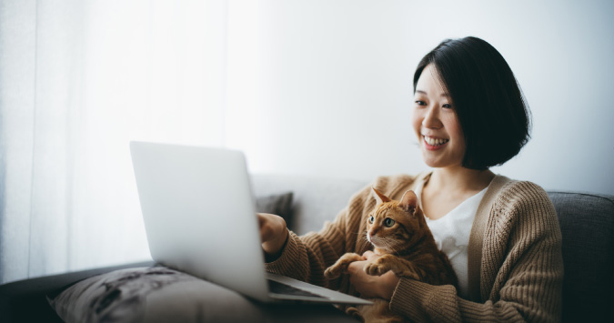 person looking at laptop with cat
