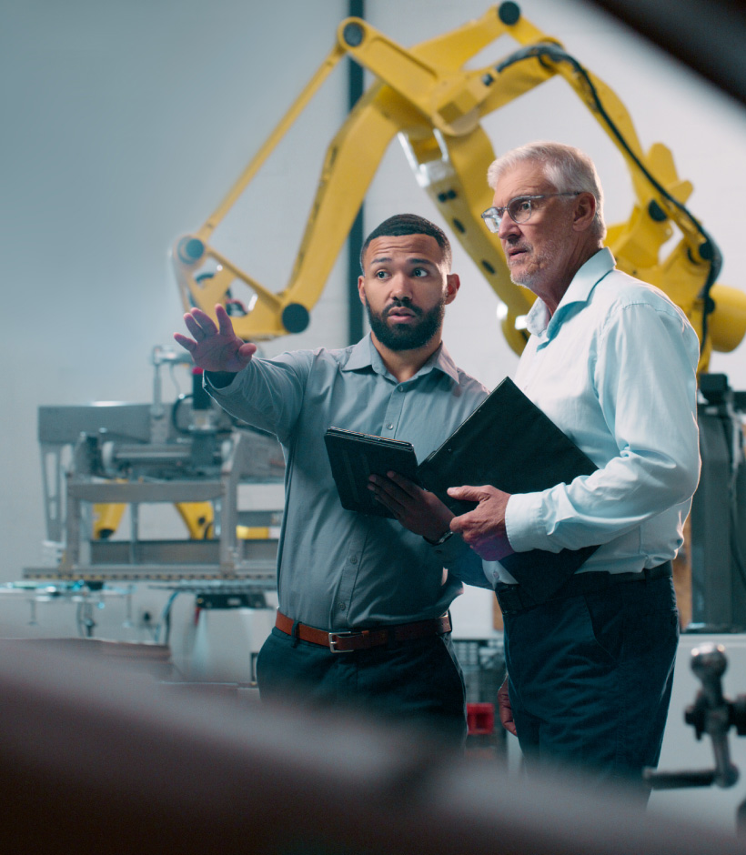 two people looking at machinery with tablets