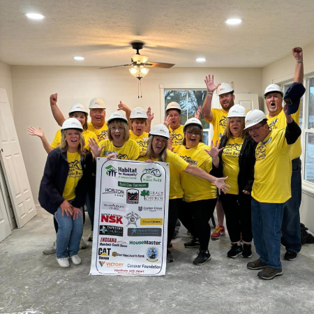 volunteers holding banner with hard hat on