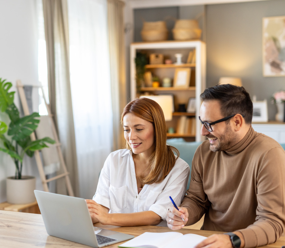 couple looking at laptop and paper