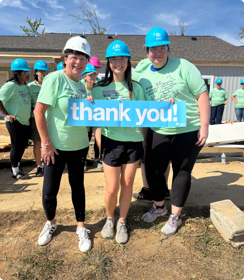 volunteers in hard hat holding "thank you" sign