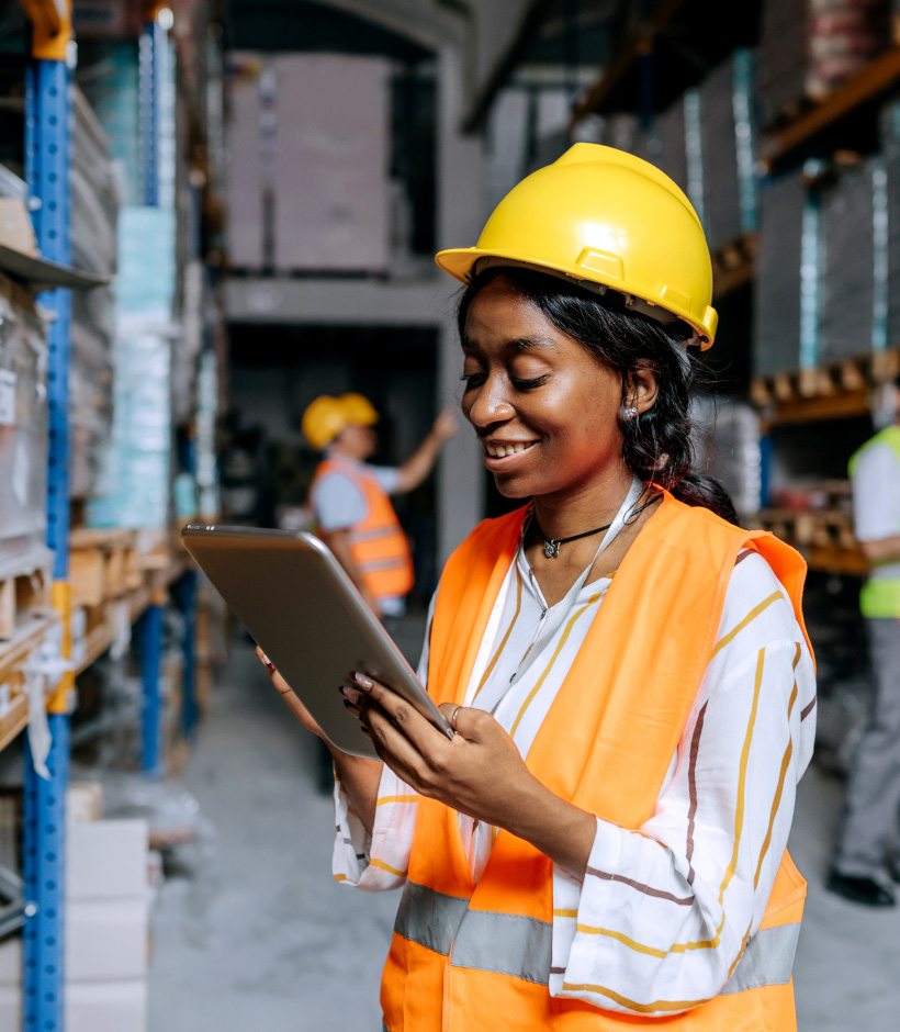 person in hard hat looking at tablet
