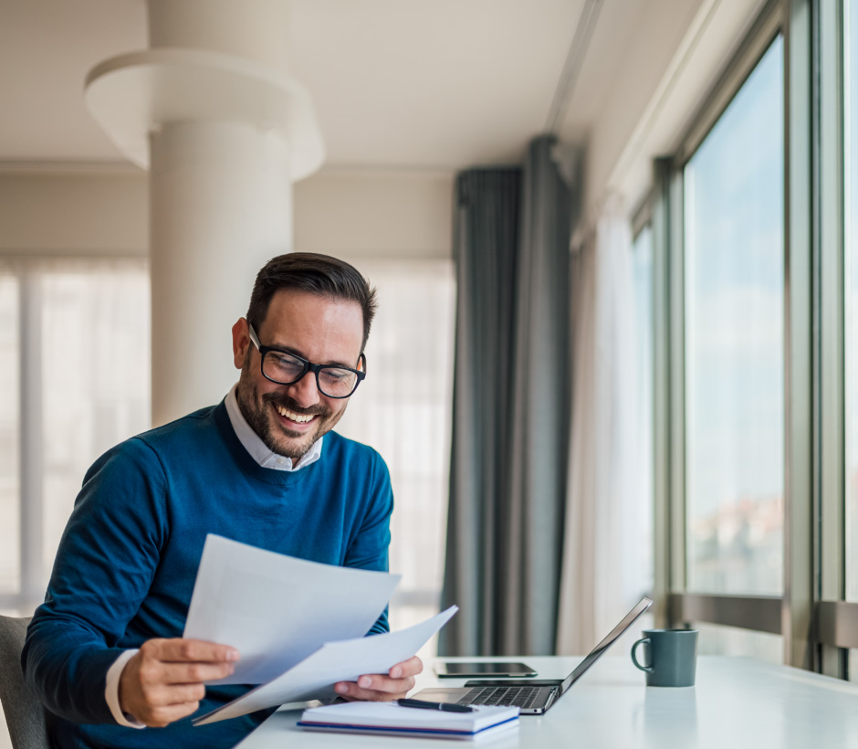 person looking at papers with laptop