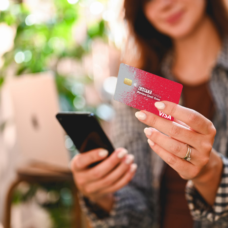 person holding card with phone