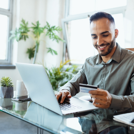 person reading credit card and laptops