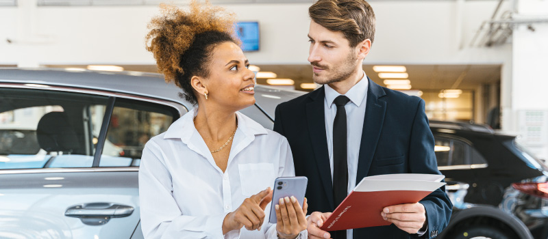 Woman at car dealership with salesman
