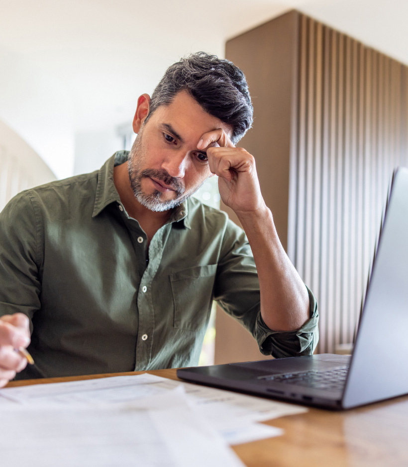 person looking at paperwork and laptop