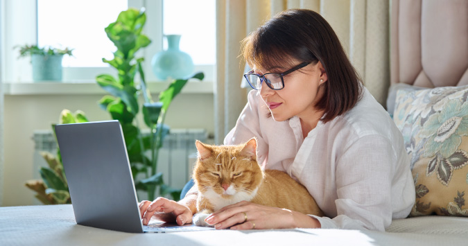 person at laptop with cat