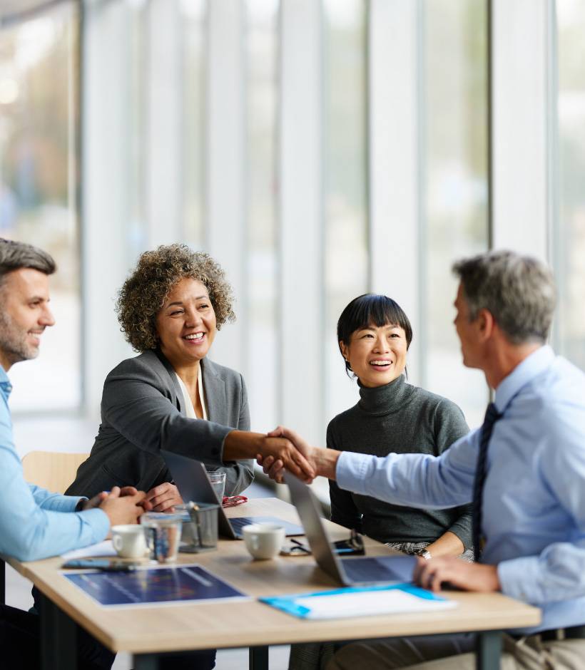 people shaking hands at business table