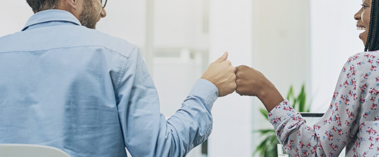 Two coworkers bumping fists